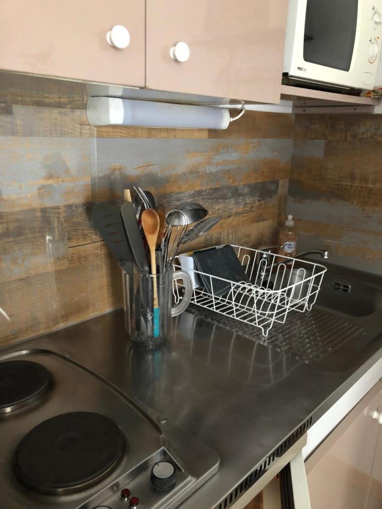 - un comptoir de cuisine avec un porte-vaisselle et des ustensiles dans l'établissement Charmant Studio, à Allos