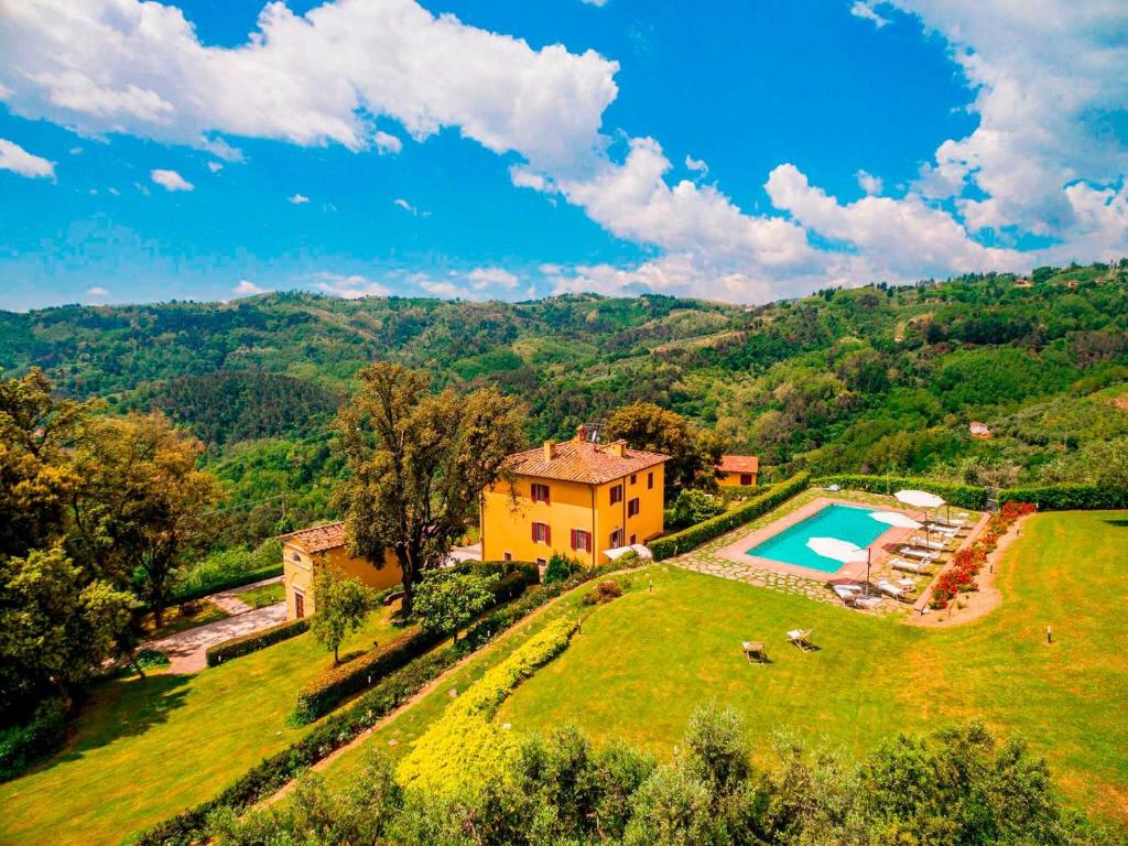 - une vue aérienne sur une maison sur une colline avec une piscine dans l'établissement Villa Armonia Toscana - Homelike Villas, à Massa e Cozzile
