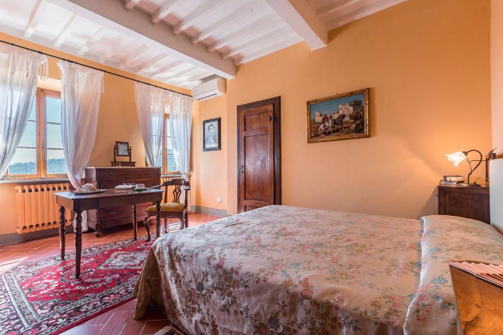 une chambre avec un lit, une table et un bureau dans l'établissement Villa Armonia Toscana - Homelike Villas, à Massa e Cozzile