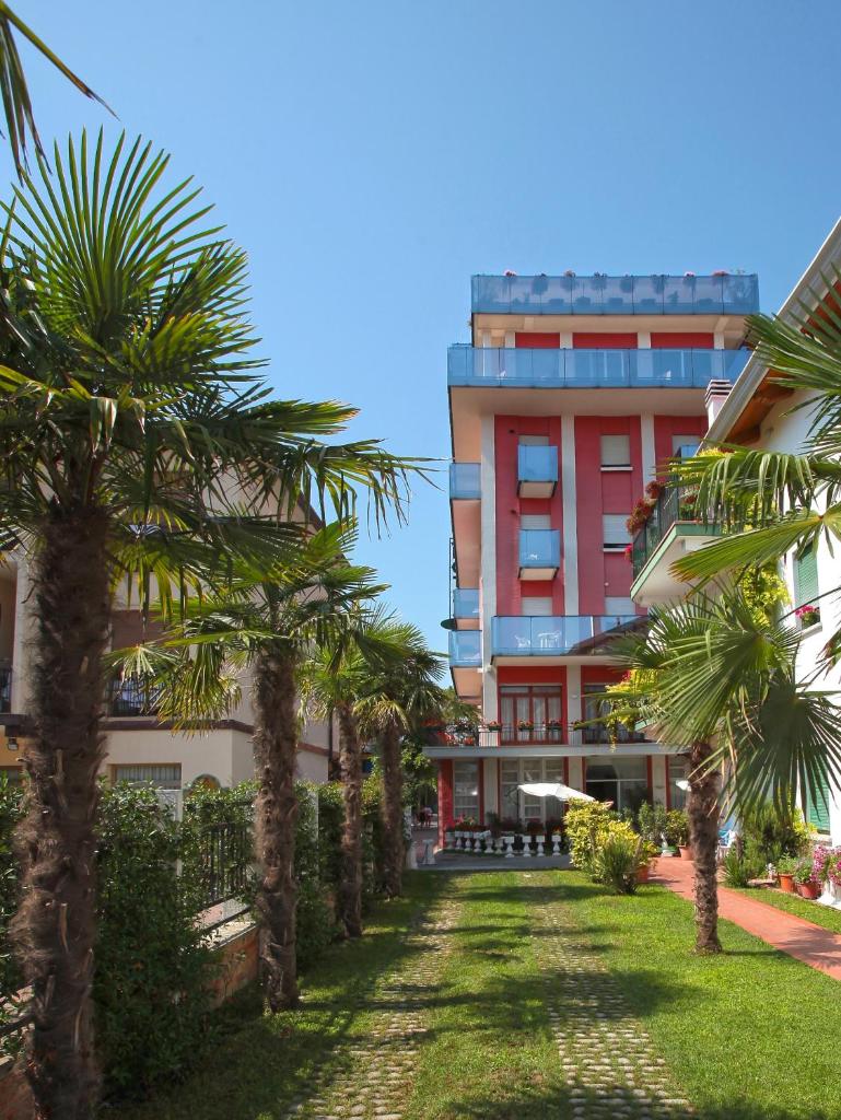 un bâtiment avec des palmiers devant dans l'établissement Hotel Smeraldo, à Lido di Jesolo
