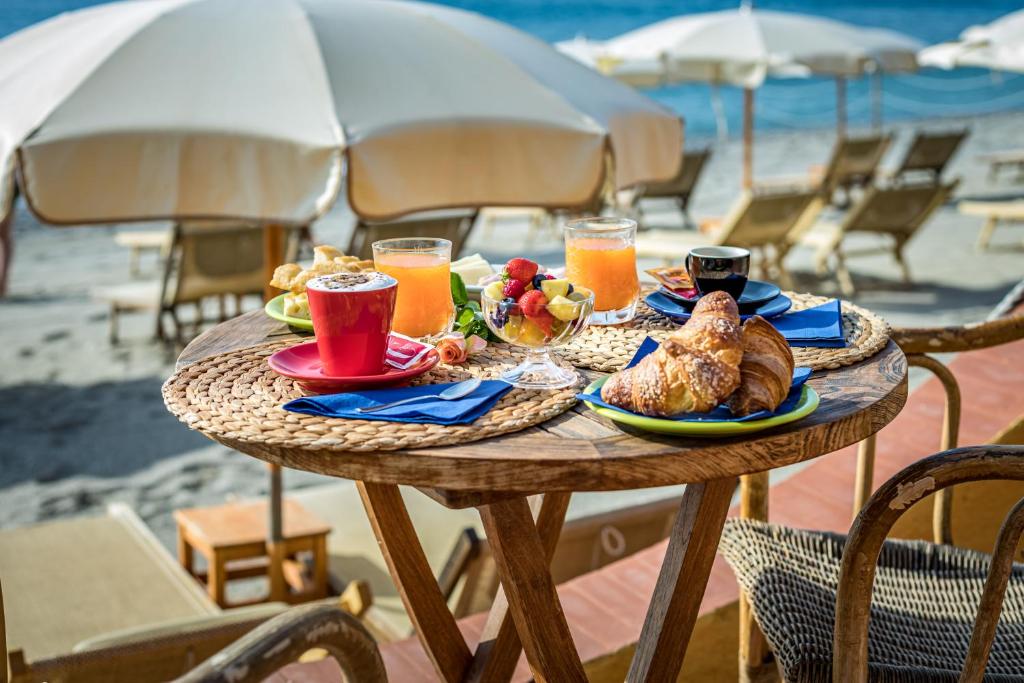 - une table avec de la nourriture et des boissons sur la plage dans l'établissement Miramare di Varigotti, à Varigotti