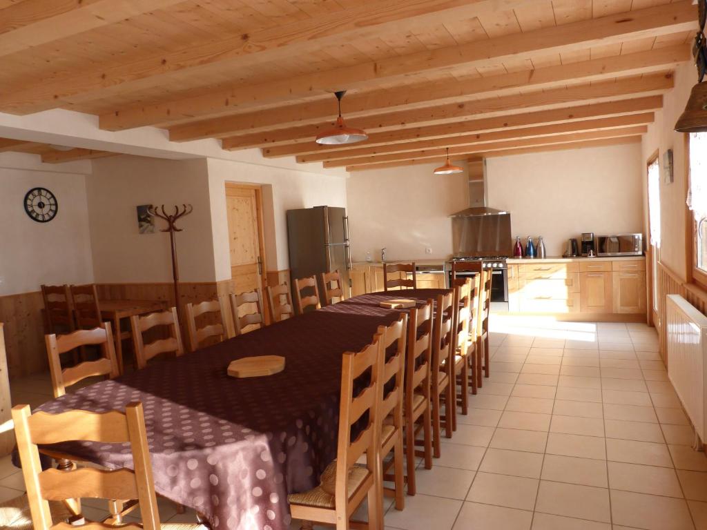 une grande salle à manger avec une longue table et des chaises dans l'établissement LA GRANGE DE HAUTE-JOUX, à Les Fourgs