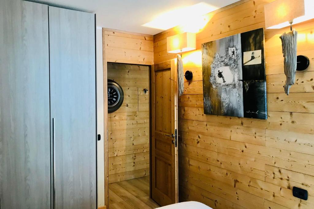 Cette chambre dispose de murs en bois, d'un placard et d'une porte. dans l'établissement In The City Center With A View Of Mont Blanc, à Chamonix-Mont-Blanc