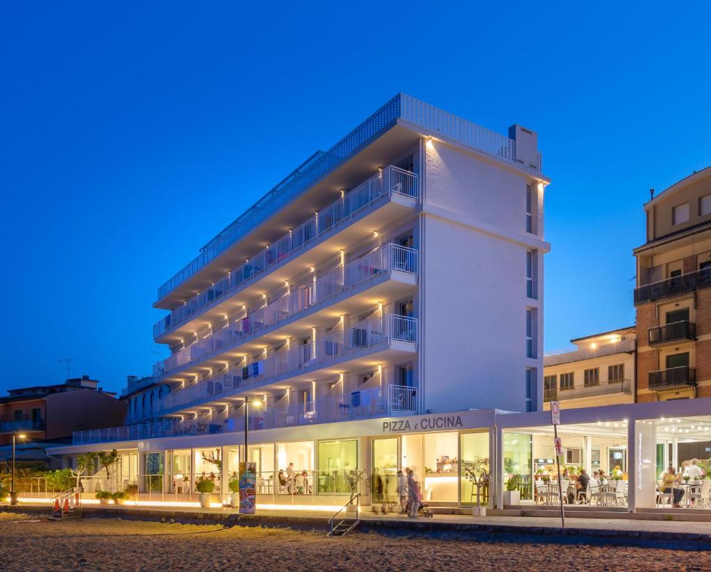un grand bâtiment blanc éclairé dans l'établissement Stellamare, à Caorle