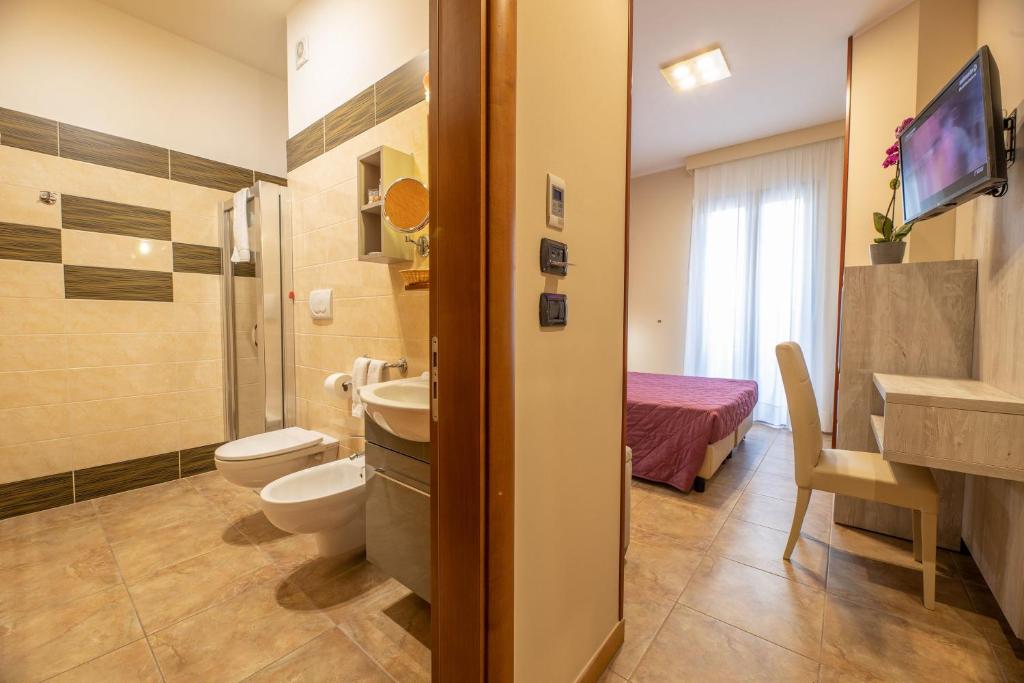 une salle de bain avec toilettes et lavabo dans l'établissement Hotel Salento Mirfran, à Torre San Giovanni