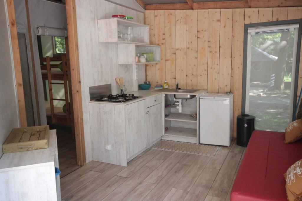 - une cuisine avec une cuisinière et un évier dans la chambre dans l'établissement Camping L'îlot du Chail, à Sansais