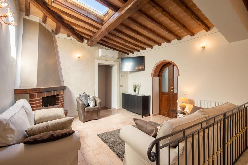 un salon avec un canapé et une cheminée dans l'établissement Casale Poggio al Vento by VacaVilla, à Sinalunga