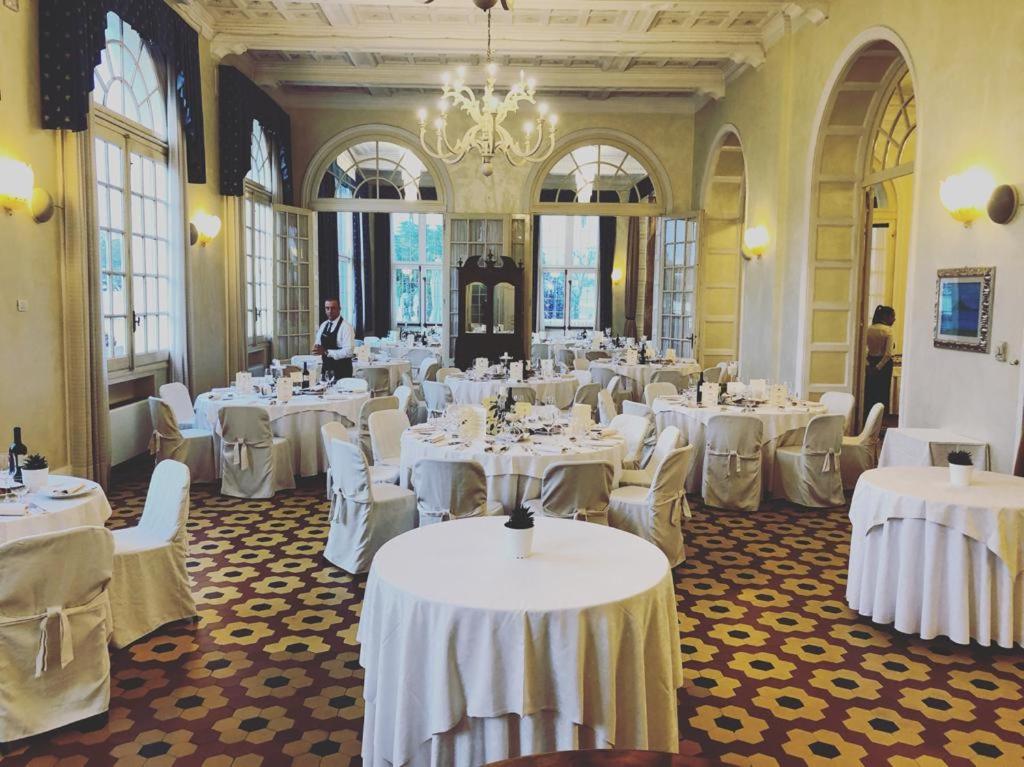 une salle de banquet avec des tables blanches et des chaises blanches dans l'établissement Grand Hotel Cesenatico, à Cesenatico