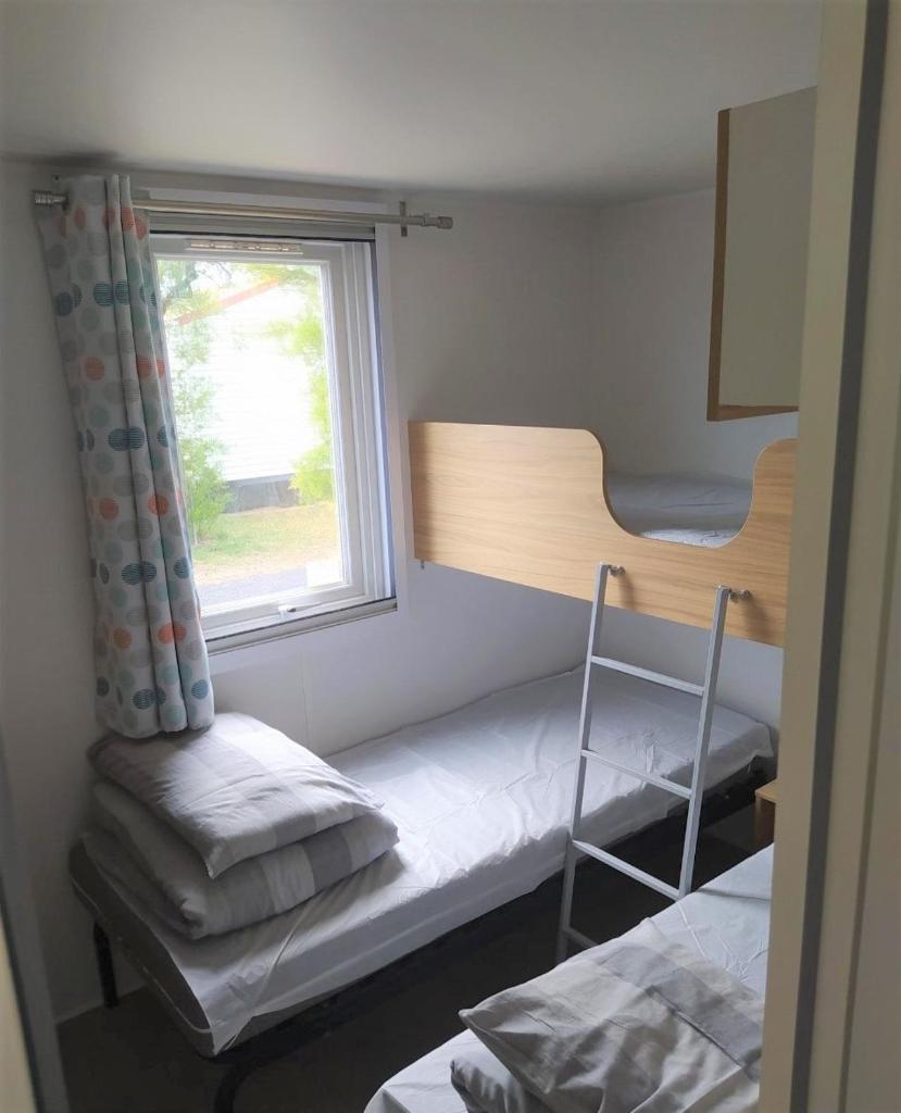 une chambre avec deux lits superposés et une fenêtre dans l'établissement Mobile Homes by KelAir at Camping Les Genets, à Saint-Jean-de-Monts