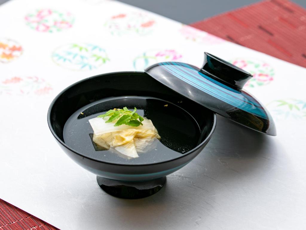 un bol noir de nourriture sur une table dans l'établissement Atami Onsen Yamaki Ryokan, à Atami