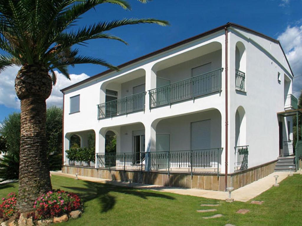 une maison blanche avec un palmier devant dans l'établissement Villa Comics, à Villammare