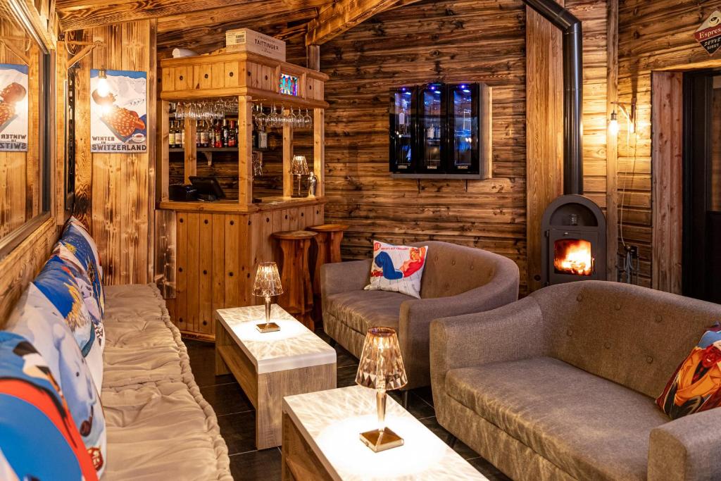 - un salon avec des canapés et une cheminée dans une cabane en rondins dans l'établissement SUNWEB Hotel L'Ecrin des Neiges, à La Joue du Loup