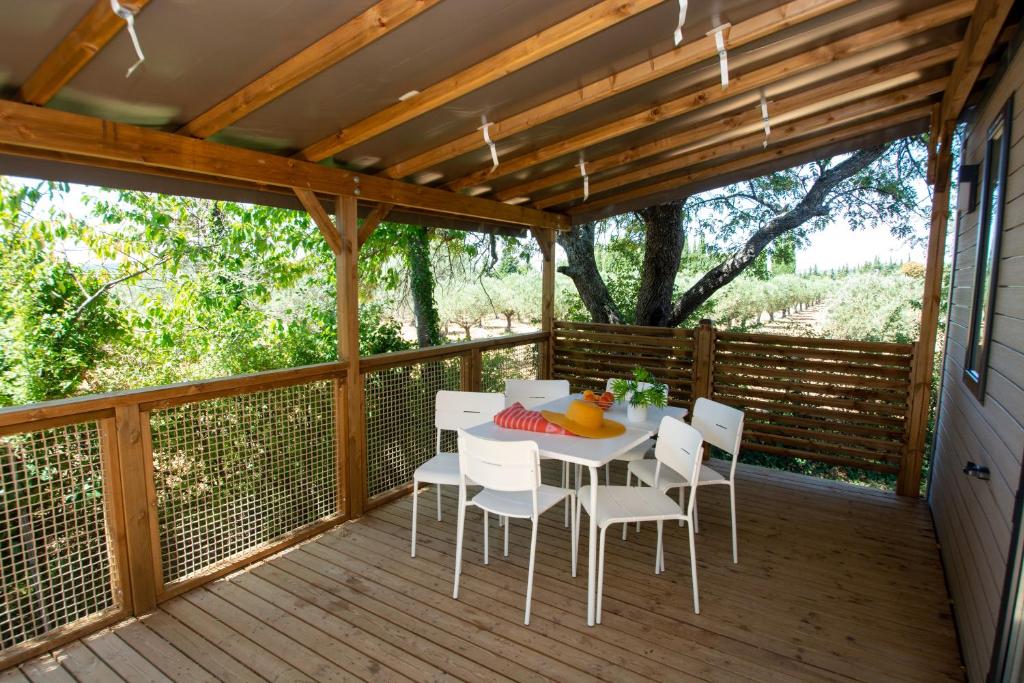 - une terrasse couverte avec une table et des chaises dans l'établissement Camping International d'Aups, à Aups