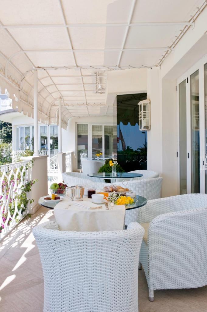 d'une terrasse avec des chaises en osier blanc et une table. dans l'établissement Hotel Il Negresco, à Forte dei Marmi