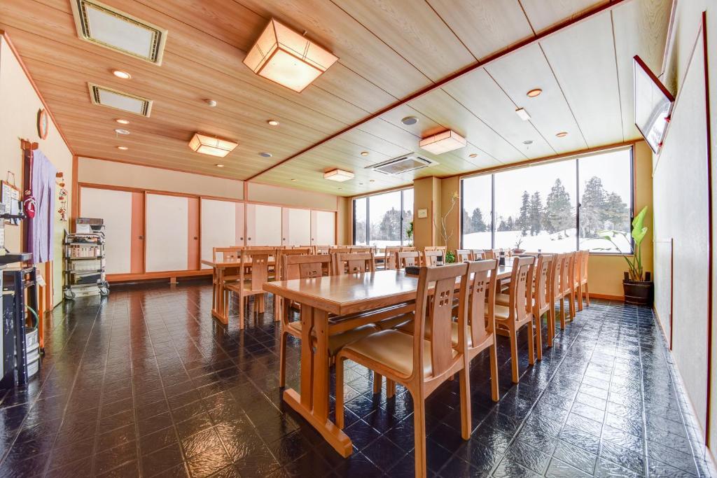 une salle à manger avec une longue table en bois et des chaises dans l'établissement Kanoe, à Iiyama