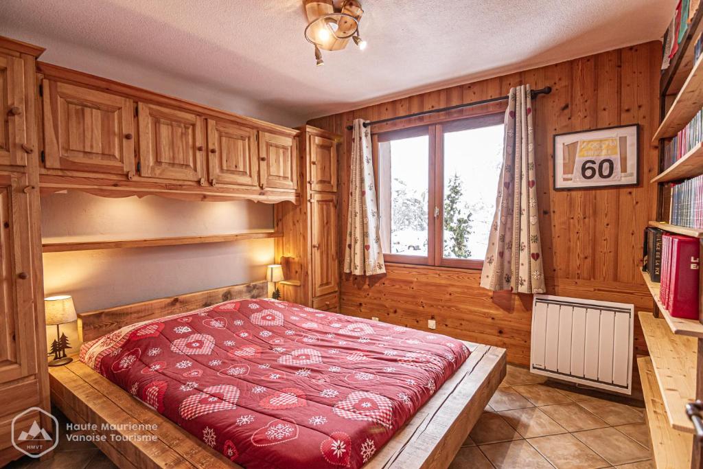 une chambre avec un lit dans une pièce avec une fenêtre dans l'établissement La Soldanelle, à Lanslevillard