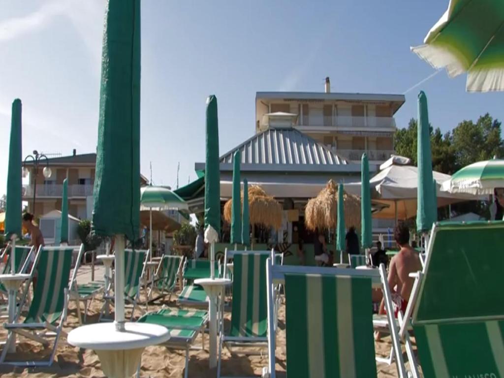 - un groupe de chaises longues et de parasols sur une plage dans l'établissement Acapulco Beach, à Lido di Jesolo