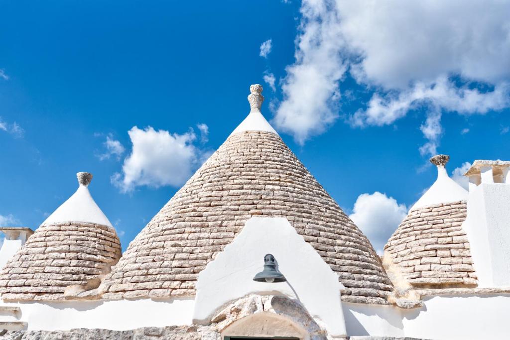 une cloche d'église avec un ciel bleu en arrière-plan dans l'établissement Trullo Paola, à Ceglie Messapica