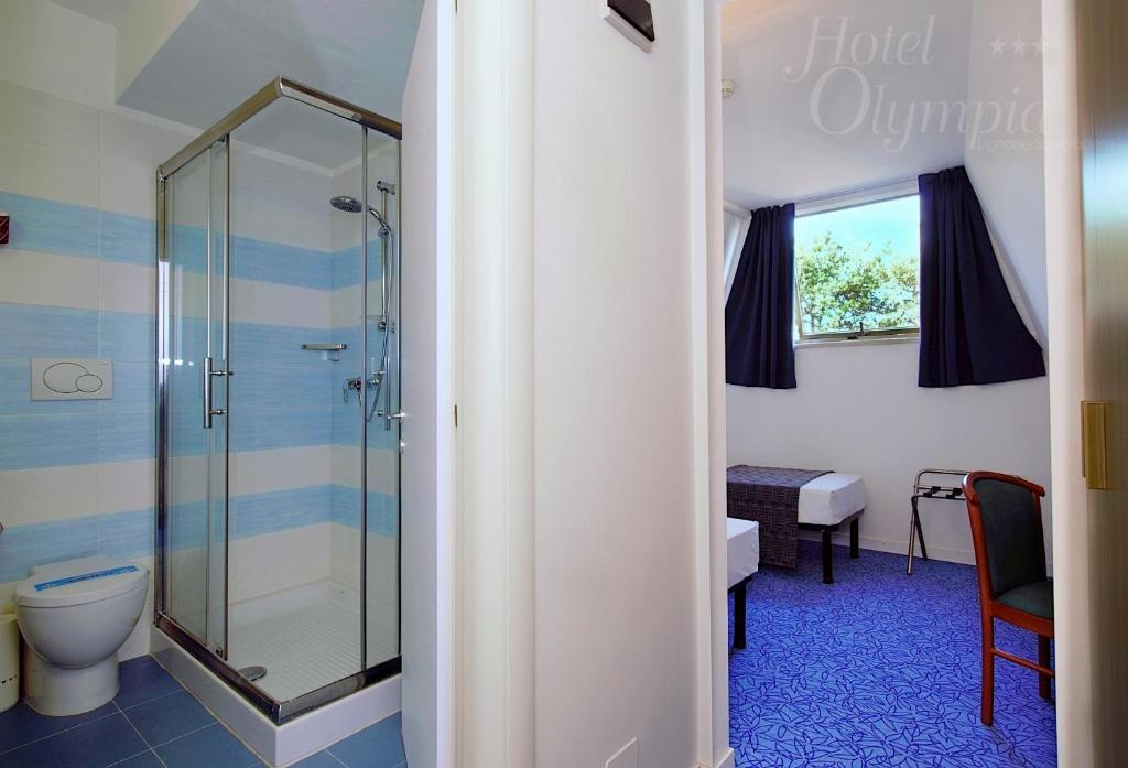 une salle de bain avec douche et toilettes dans l'établissement Hotel Olympia, à Lignano Sabbiadoro