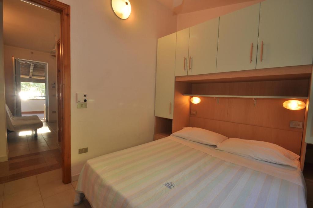 une chambre avec un lit et une chaise dedans dans l'établissement RESIDENCE LA DARSENA, à Isola di Capo Rizzuto