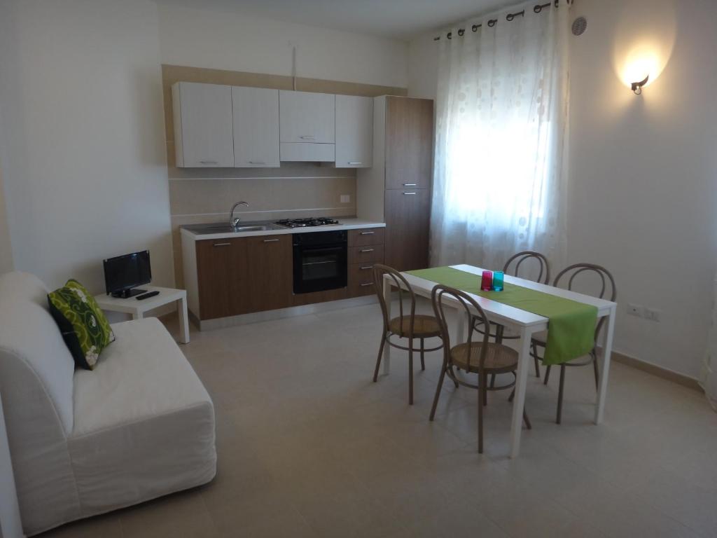 une cuisine et un salon avec une table et des chaises dans l'établissement Residenza Ondanomala, à Chieuti
