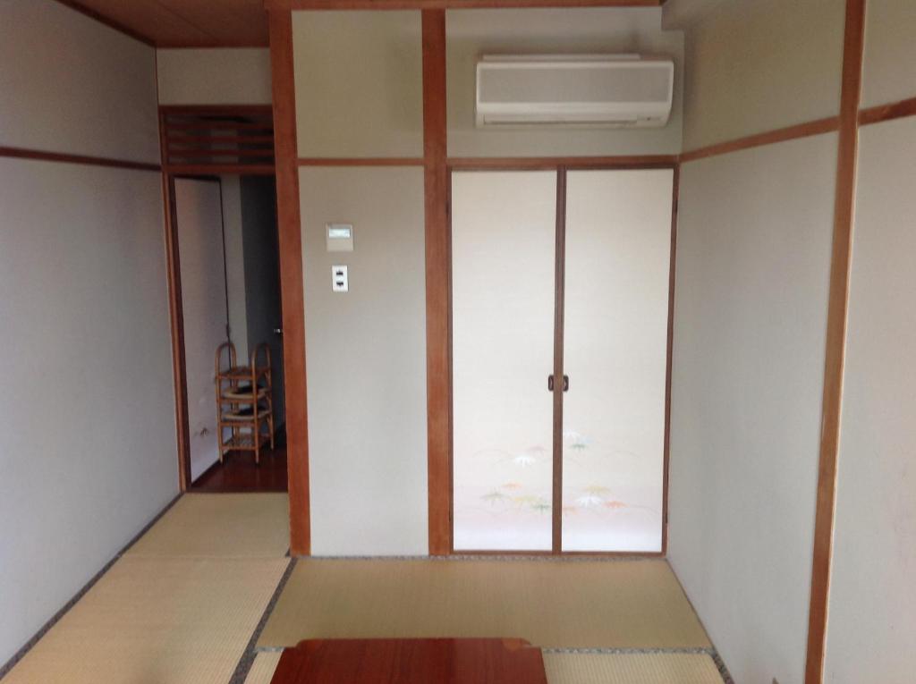 une chambre vide avec une porte et une fenêtre dans l'établissement Yamaichi Bekkan, à Miyajima