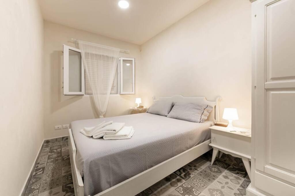 une chambre blanche avec un lit avec deux serviettes dessus dans l'établissement Villa Ferrante, à Marina di Ragusa 31 autres photos