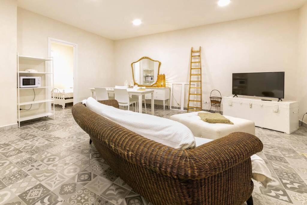 - un salon avec une télévision, un canapé et une table dans l'établissement Villa Ferrante, à Marina di Ragusa