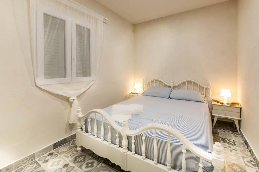 une chambre blanche avec un lit blanc et une fenêtre dans l'établissement Villa Ferrante, à Marina di Ragusa