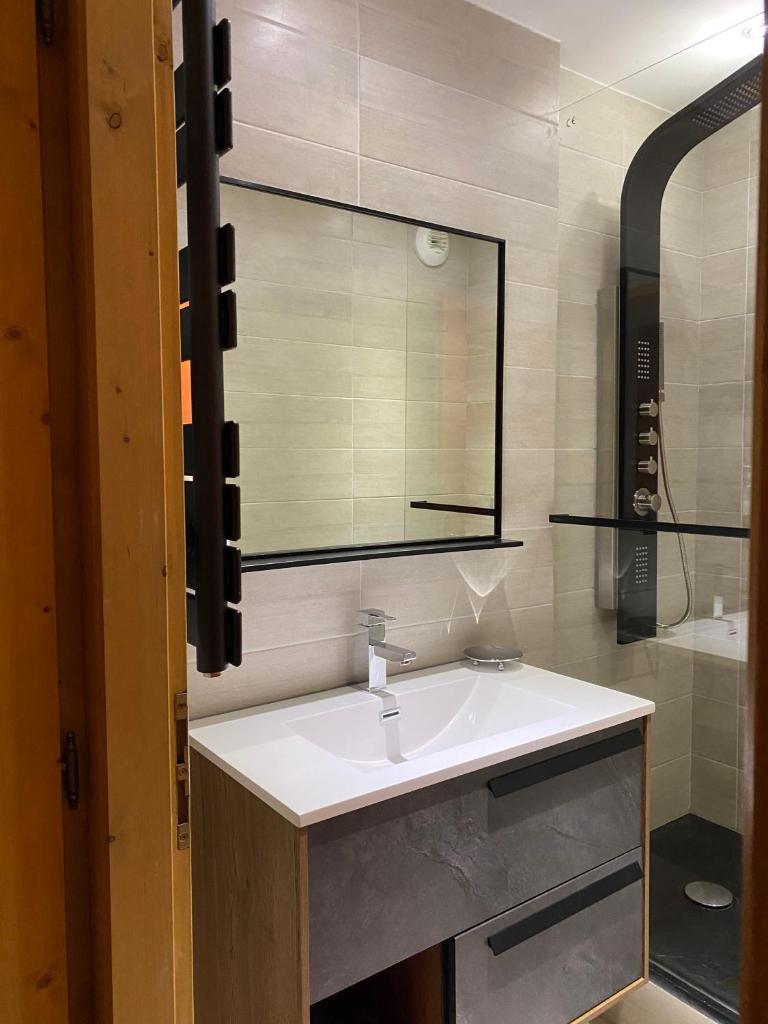une salle de bain avec un lavabo et un miroir dans l'établissement Superbe appt 2 chambres Arc 1950, à Arc 1950 14 autres photos