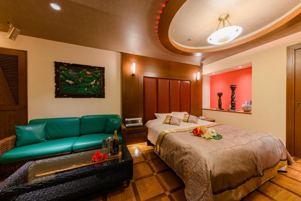 une chambre d'hôtel avec un lit et un canapé dans l'établissement HOTEL MYTH-S -ホテル マイス エス- adult only, à Sakaide