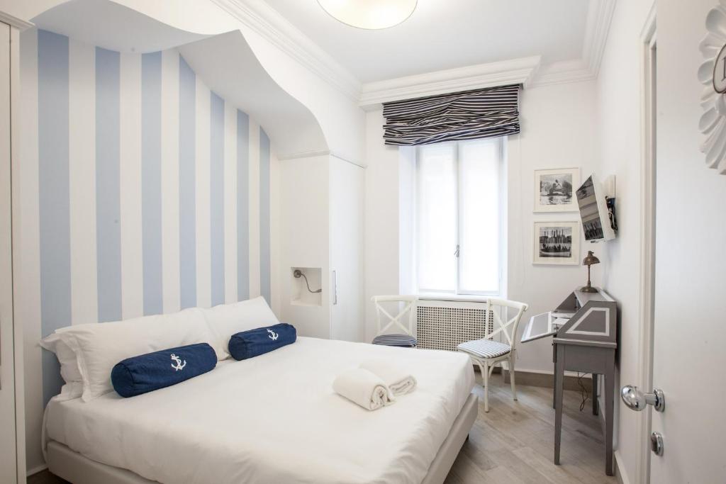 une chambre avec un lit blanc et un bureau dans l'établissement Hotel Marina Charming Rooms, à Finale Ligure