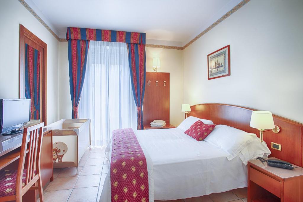 une chambre d'hôtel avec un lit et une télévision dans l'établissement Hotel Agostini, à Bellaria-Igea Marina
