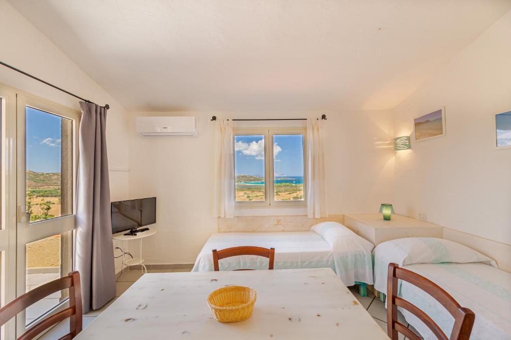 une chambre avec deux lits, une table et une fenêtre dans l'établissement Residence Hotel Lu Nibareddu, à San Teodoro 110 autres photos