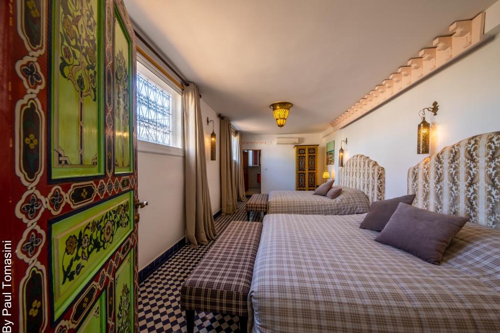 une chambre d'hôtel avec deux lits et une fenêtre dans l'établissement Riad Fes Nass Zmane, à Fès
