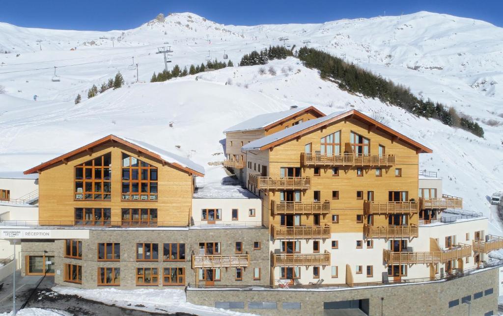 un grand bâtiment avec de la neige sur une montagne dans l'établissement Résidence Prestige Odalys Rochebrune Les Cimes, à Orcières