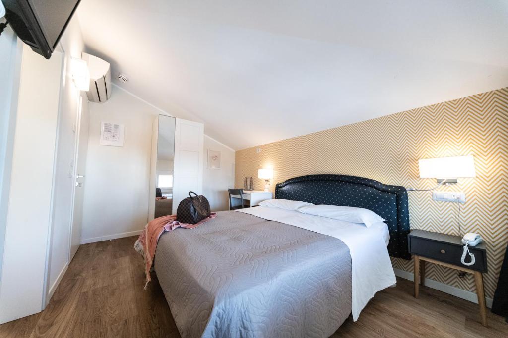 une chambre avec un grand lit dans une pièce dans l'établissement Hotel Kiss, à Riccione