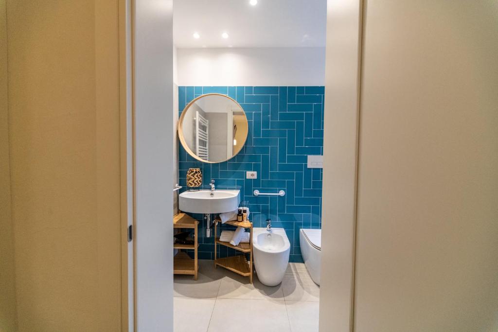 une salle de bain avec un lavabo, des toilettes et un miroir dans l'établissement Hotel Kiss, à Riccione