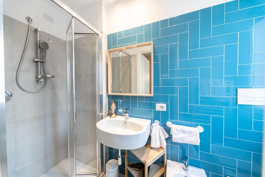 une salle de bain carrelée bleue avec un lavabo et une douche dans l'établissement Hotel Kiss, à Riccione 32 autres photos
