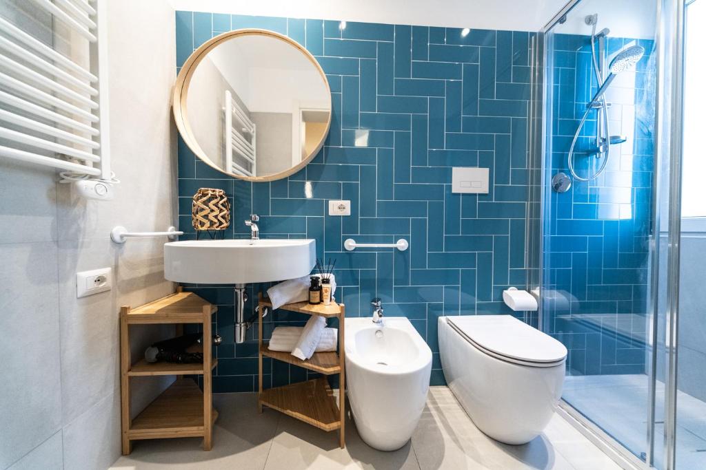une salle de bain avec un lavabo, des toilettes et un miroir dans l'établissement Hotel Kiss, à Riccione