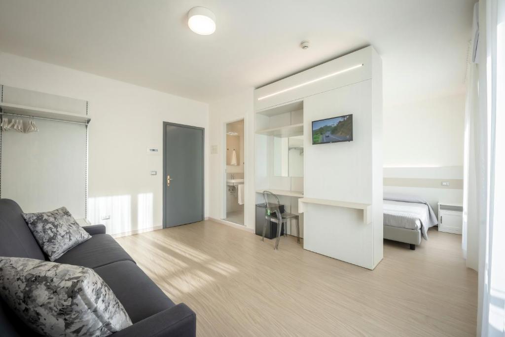 un salon avec un canapé et une chambre dans l'établissement Hotel Portofino, à Caorle