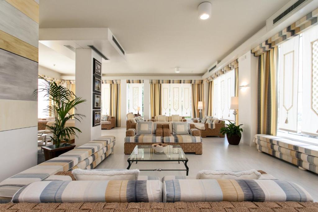 un grand salon avec des canapés et une table dans l'établissement Hotel Delle Mimose, à Lido di Jesolo