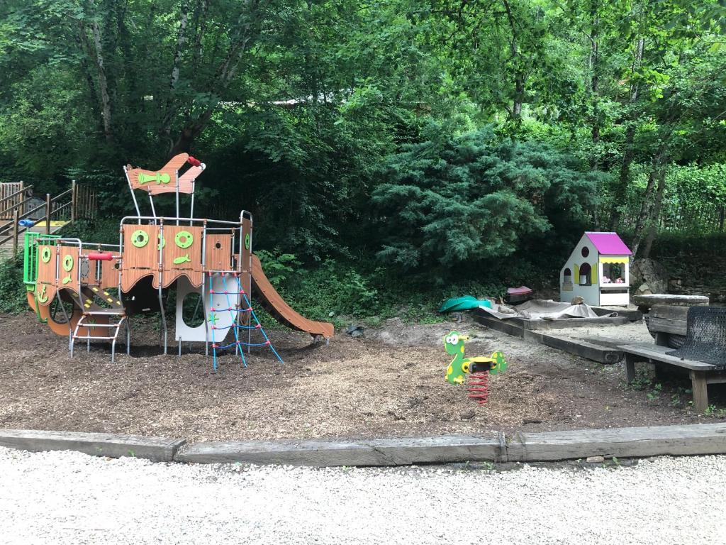une aire de jeux avec un jeu et un toboggan dans l'établissement Camping Moulin De Chaules, à Saint-Constant
