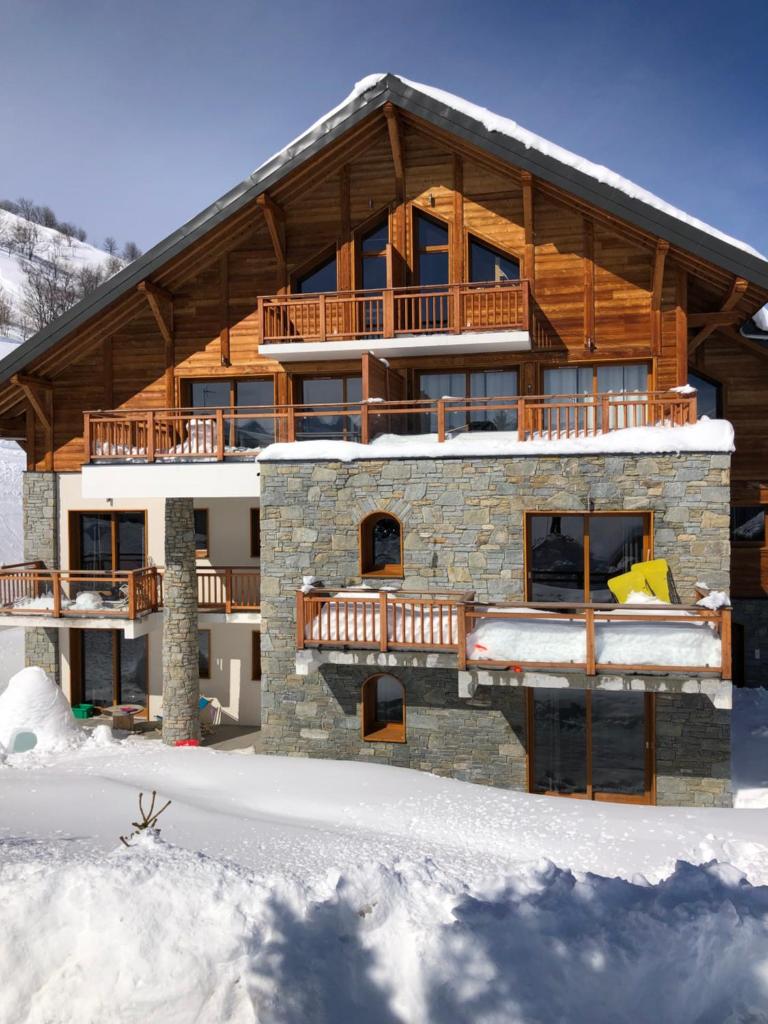 une maison dans la neige avec un balcon dans l'établissement Chalet Skiopied, à La Toussuire