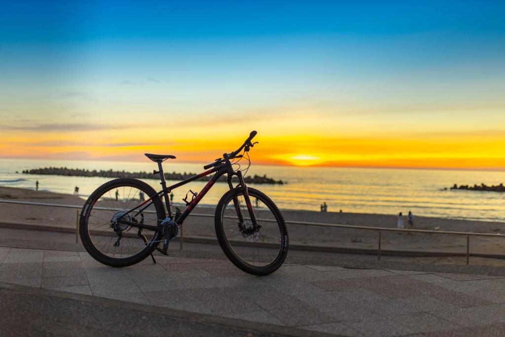 un vélo garé sur un trottoir à côté de la plage dans l'établissement B&B MIKAWA - Kanazawa Fish Harbour, à Kanazawa