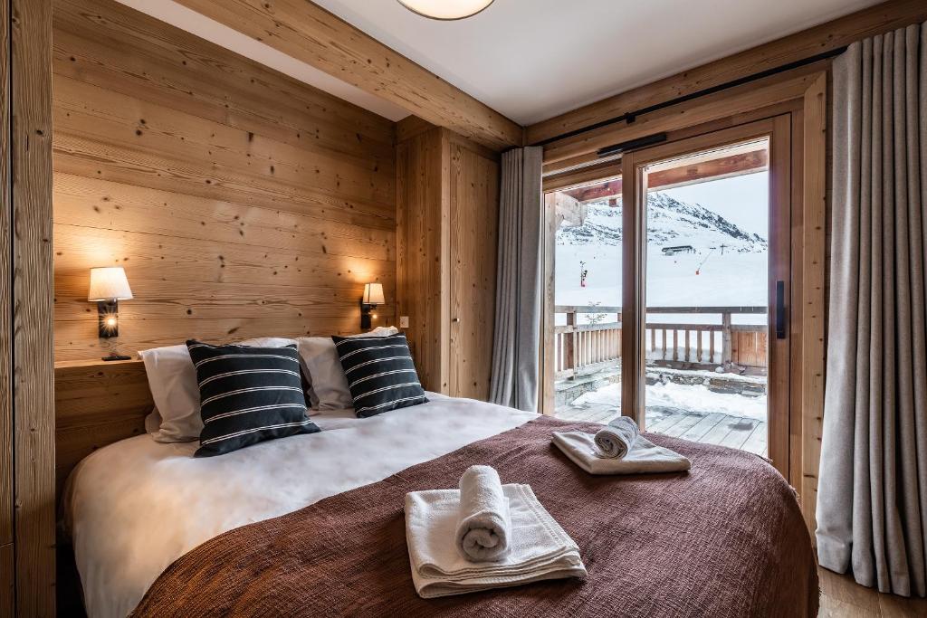 une chambre avec un grand lit avec des serviettes dessus dans l'établissement Apartment Wapa Alpe d'Huez - by EMERALD STAY, à L'Alpe-d'Huez