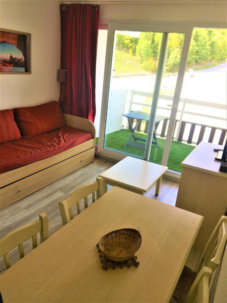 un salon avec une table, des chaises et un canapé dans l'établissement Skis aux pieds station 1600 Sun Vallée, à Puy-Saint-Vincent