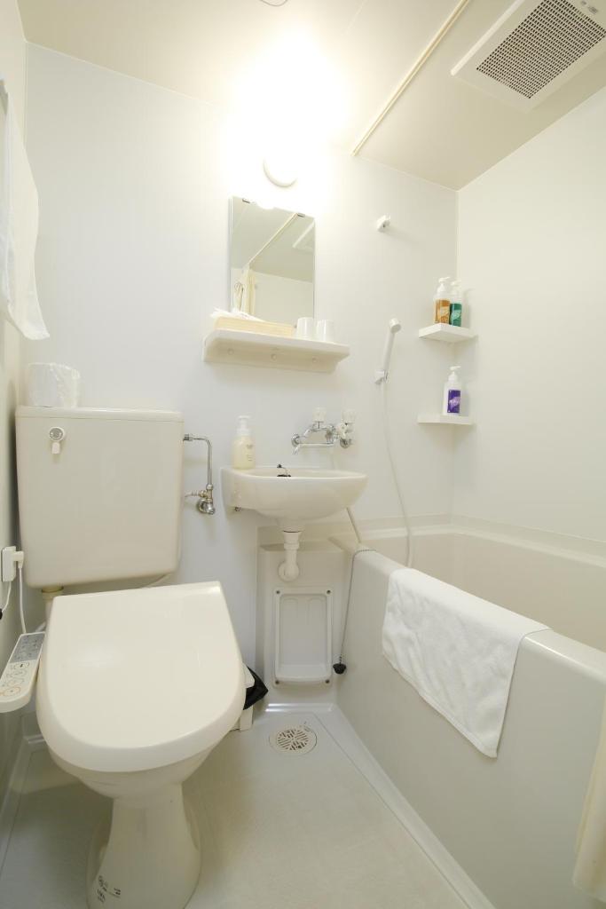 une salle de bain blanche avec des toilettes et un lavabo dans l'établissement Toya-onsen Hotel Hanabi, à Lac Tōya