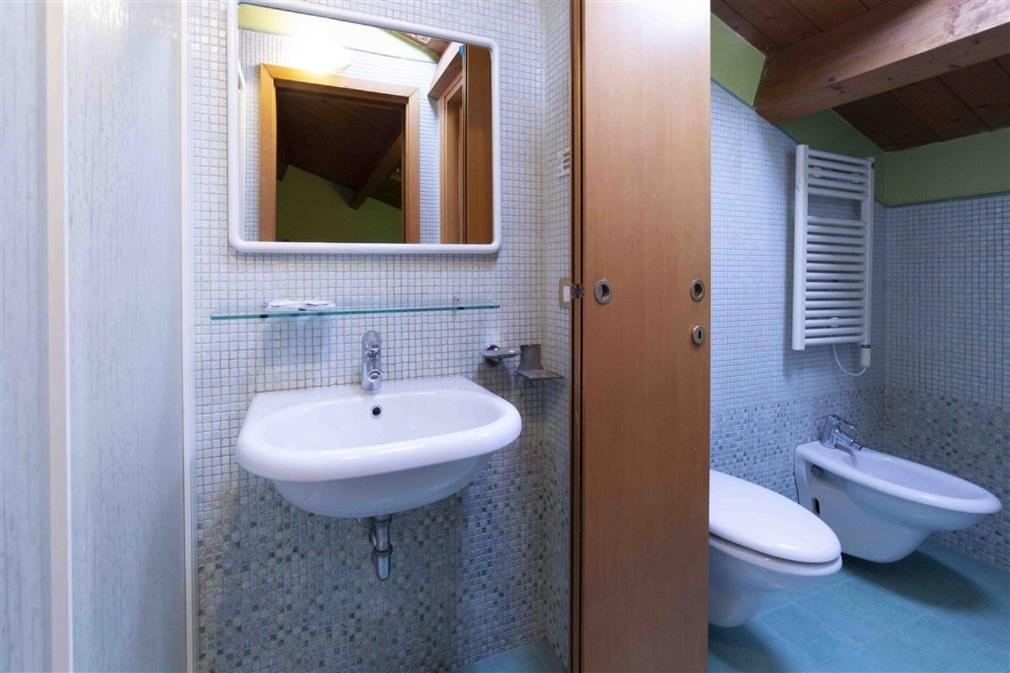 une salle de bain avec un lavabo, des toilettes et un miroir dans l'établissement Residenza Melucci, à Rimini 61 autres photos