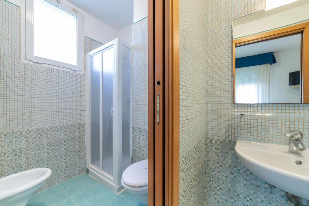 une salle de bain avec un lavabo, des toilettes et un miroir dans l'établissement Residenza Melucci, à Rimini